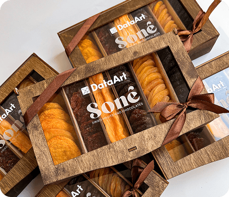 Wooden gift boxes tied with brown ribbon, filled with dried apricots, plums, and raisins under a custom client logo