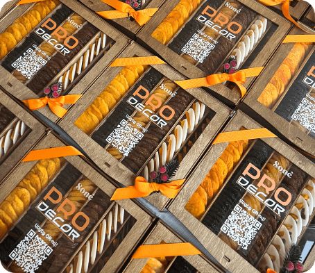 Wooden gift boxes tied with orange ribbon, filled with dried fruit and rolled white nougat under a custom client logo
