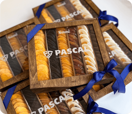 Wooden gift boxes tied with navy ribbon, filled with dried fruit and rolled white nougat under a custom client logo